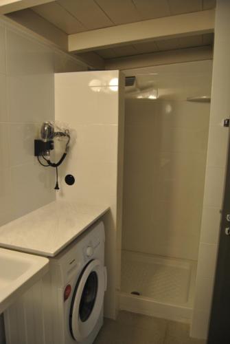 a bathroom with a washing machine and a shower at LEONIDIONHOUSES - The Lykoskufi Villas in Tiros