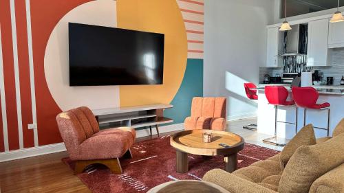 a living room with a couch and chairs and a tv at Chic 2 BR 1 Parking Sleeps 6 in Chicago
