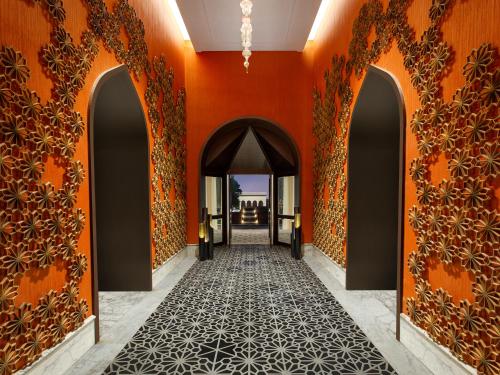 a hallway with orange walls and an archway at Welcomhotel by ITC Hotels, Raja Sansi, Amritsar in Amritsar