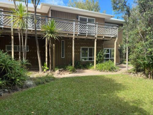 a house with palm trees in front of it at The Nature Hub in Parua Bay