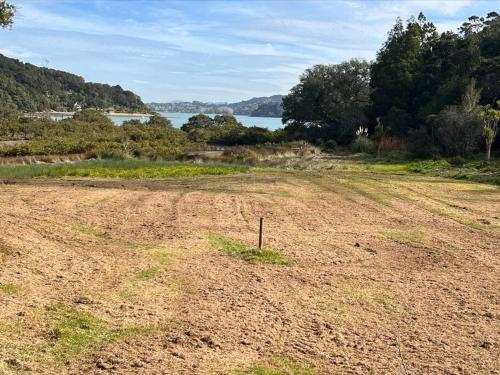 an empty field with a view of the water at The Nature Hub in Parua Bay