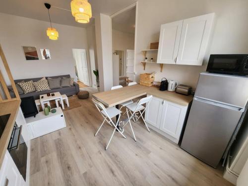 Il dispose d'une cuisine et d'un salon avec une table et un réfrigérateur. dans l'établissement Superbe T4 entièrement rénové - Eurexpo-Stade-Lyon, à Saint-Priest