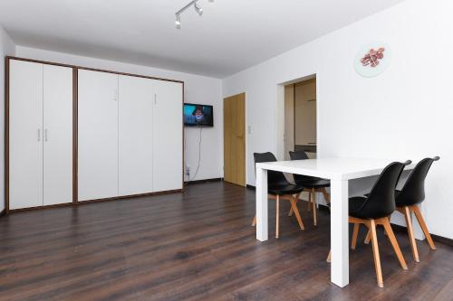 a white dining room with a white table and chairs at Haus Hafenromantik in Neuharlingersiel