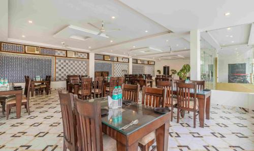 a dining room with tables and chairs in a restaurant at Treebo Tiger Pug Mark Resort with Pool in Rāmnagar