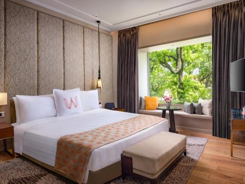 a bedroom with a large white bed and a window at Welcomhotel by ITC Hotels, Raja Sansi, Amritsar in Amritsar