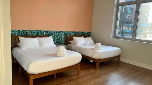 two beds sitting in a room with a window at Chic 2 BR 1 Parking Sleeps 6 in Chicago