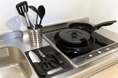 a stove top with a pot on it next to a sink at Maison Asch Ikebukuro by Tranova in Tokyo