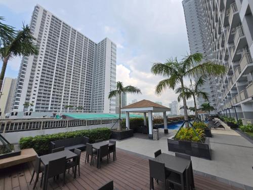 an outdoor patio with tables and chairs and buildings at 2BR Solana Suite near MOA PICC NAIA in Manila