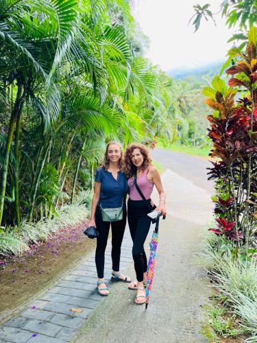 two women are walking down a path with a skateboard at Fab Valley Homestay in Munnar