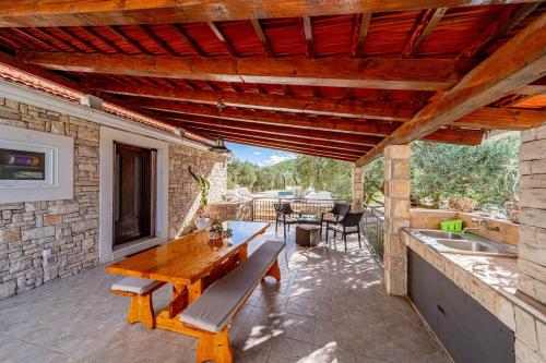an outdoor patio with a wooden table at Pool House Potirna - Happy Rentals in Blato