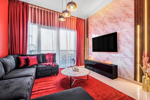 a living room with a black couch and a tv at Dubai Marina 3BR Penthouse with Stunning JBR, Marina & Dubai Eye Views in Dubai