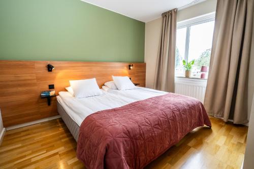 a bedroom with a large bed and a window at Berling Apartments in Karlstad
