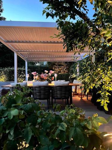 a patio with a table and chairs under a pergola at Luxurious villa - exceptional location in city center with free P in Odense