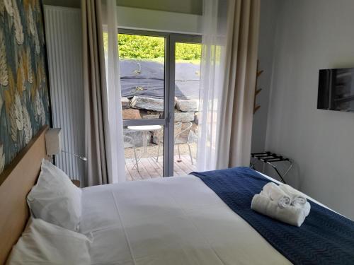 a bedroom with a bed with towels on it at The Originals City, Ara Hôtel, Landerneau in Landerneau