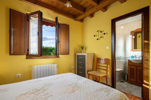 ein Schlafzimmer mit einem Bett und einem Waschbecken sowie ein Badezimmer in der Unterkunft Apto Amarillo - Casa el gaitero in Susacasa