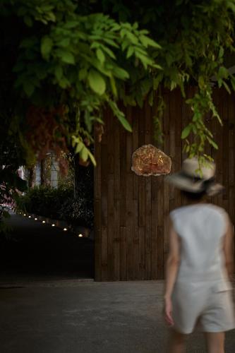 a woman in a hat walking down a street at Mila Qi Ting Li Guest House Shanghai in Shanghai