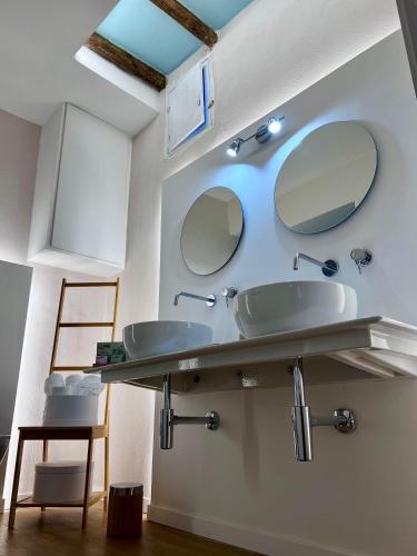 a bathroom with two sinks and two mirrors at Elena's Suite in Sutri
