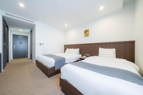 全州市にあるDavin Hotelのベッド2台と廊下が備わるホテルルームです。