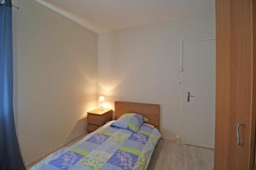 a bedroom with a bed and a lamp on a table at Gîte Les Champs N°2 in Saint-Mathieu