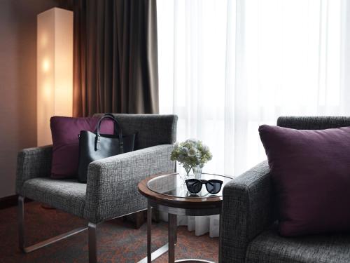a living room with two chairs and a coffee table at Pullman Hanoi in Hanoi
