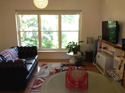 a living room with a couch and a table at Picture Perfect Toorak, entire apartment in Melbourne
