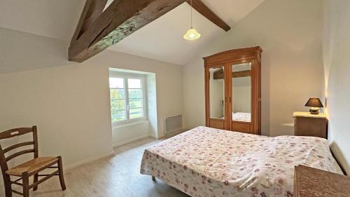 a bedroom with a bed and a chair and a window at Gîte Les Champs N°3 in Saint-Mathieu