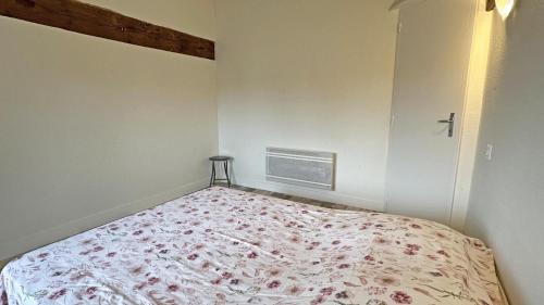 a bedroom with a bed with a floral bedspread at Gîte Les Champs N°3 in Saint-Mathieu