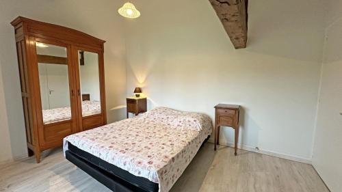 a bedroom with a bed and a mirror at Gîte Les Champs N°3 in Saint-Mathieu
