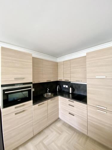 une cuisine avec des armoires en bois et un évier dans l'établissement Elegant studio MEN5335, à Cannes