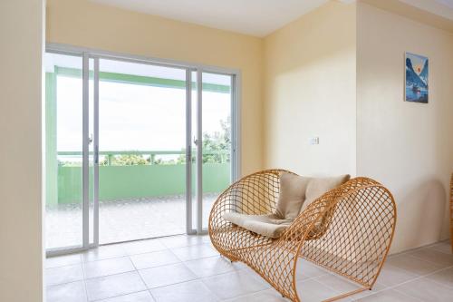 a wicker chair in a room with a window at Villa Jolam - Family haven in an island paradise in Camotes Islands