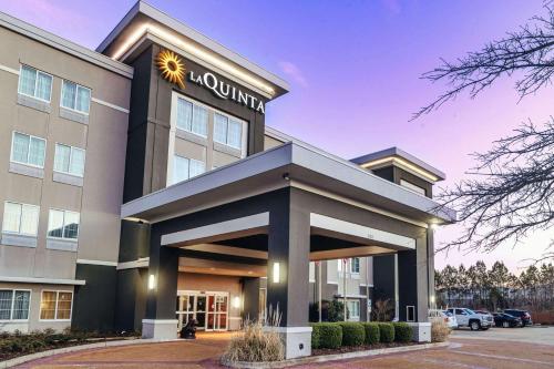 a front view of a hotel with a building at La Quinta by Wyndham Starkville at MSU in Starkville