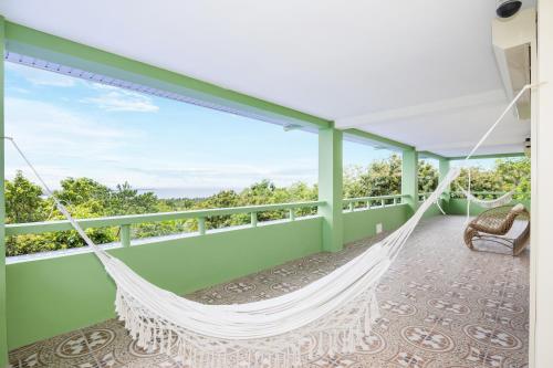a hammock on the balcony of a house at Villa Jolam - Family haven in an island paradise in Camotes Islands