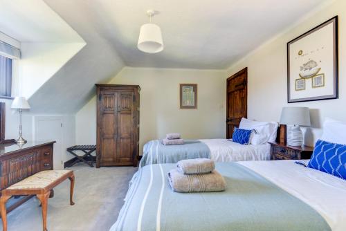 a bedroom with two beds and a chair in it at Oldfield house, walking distance of pub & sea in West Itchenor
