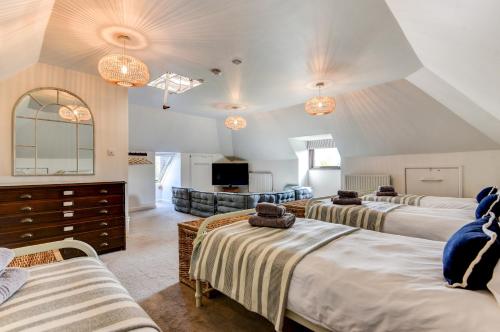 a bedroom with three beds and a living room at Oldfield house, walking distance of pub & sea in West Itchenor