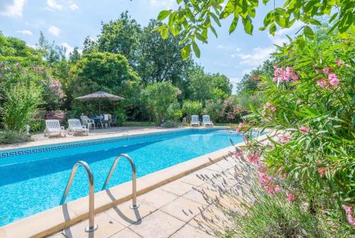 - une piscine dans une cour ornée d'arbres et de fleurs dans l'établissement 30ciga, à Saint-Brès