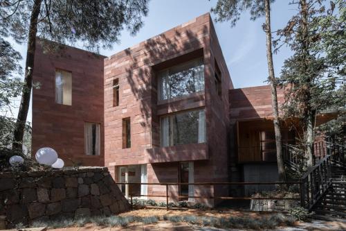 a wooden house in the middle of a forest at Vretreats Suyunjian Boutique Hotel in Xinglong
