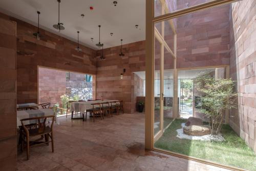 a dining room with a table and chairs and windows at Vretreats Suyunjian Boutique Hotel in Xinglong