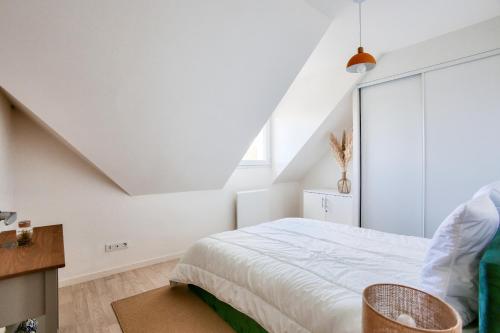 a white bedroom with a bed and a window at Centre-ville Pléneuf Val André, appartement pour 4 in Pléneuf-Val-André