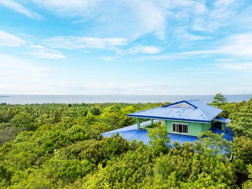 a house in the forest with a blue roof at Villa Jolam - Family haven in an island paradise in Camotes Islands