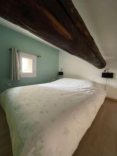 une chambre avec un grand lit blanc avec une fenêtre dans l'établissement Ma fenêtre sur le Vieux Port!, à Marseille