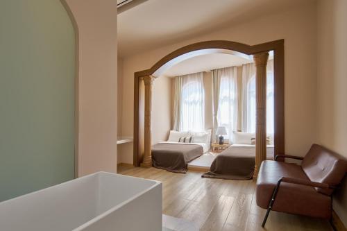 a bedroom with two beds and a chair and a mirror at Mila Qi Ting Li Guest House Shanghai in Shanghai