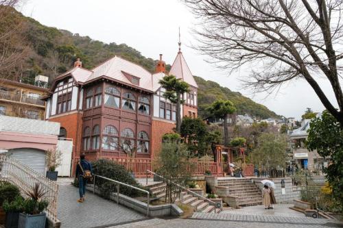 a large brick building with people walking in front of it at Green Hill Hotel Urban in Kobe
