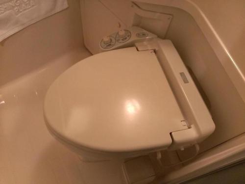 ein Badezimmer mit einem weißen WC in einer Badewanne in der Unterkunft Takamatsu Washington Hotel Plaza in Takamatsu