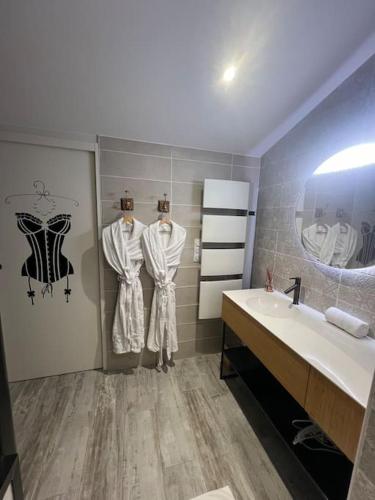 La salle de bains est pourvue d'un lavabo et d'un miroir. dans l'établissement Love room avec spa privé, au Perrier