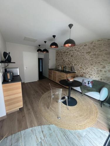 un salon avec un canapé et une table dans l'établissement Love room avec spa privé, au Perrier