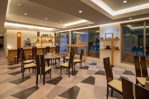 a dining room with tables and chairs in a restaurant at Hotel Myoken Tanaka Kaikan in Kirishima