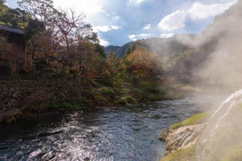 a view of a river with mountains in the background at Hotel Myoken Tanaka Kaikan in Kirishima