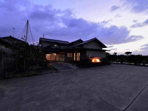 a house with a lit driveway in front of it at Minshuku Shima in Kaga