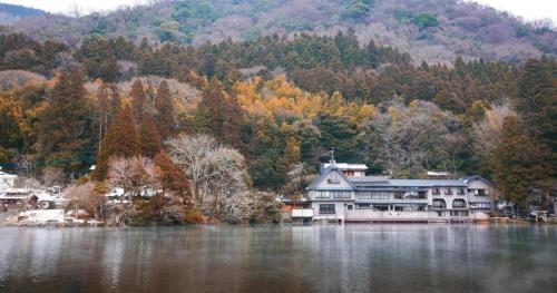 a large house sitting on the side of a lake at Secret Base Tokinokakera in Yufuin
