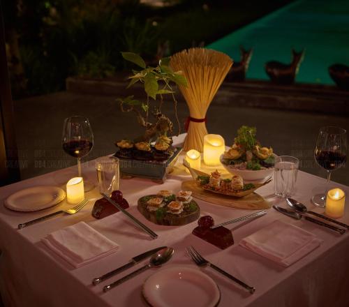 a table with food and candles and glasses of wine at aNhill Boutique in Hue